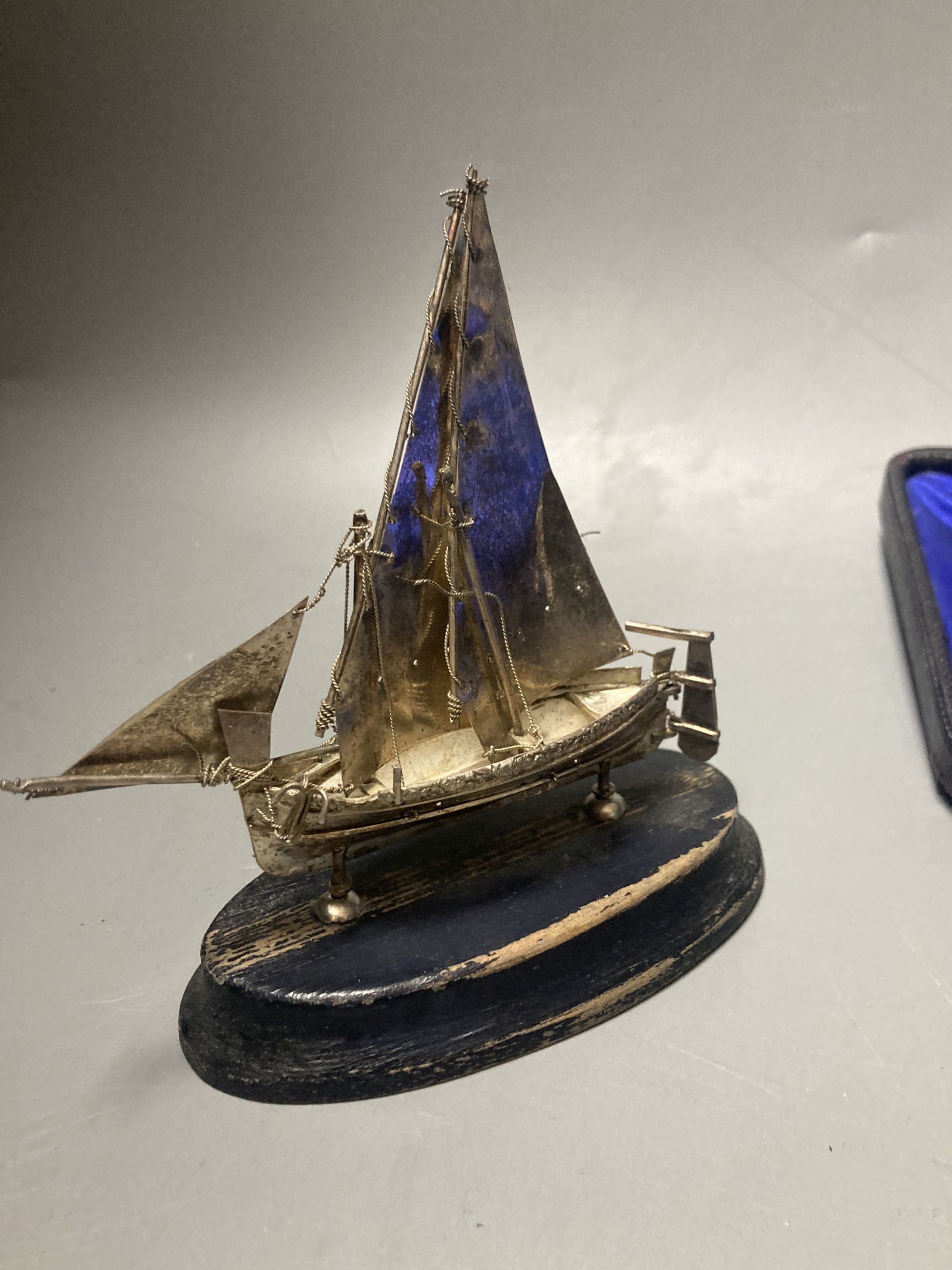 A cased silver handled button hook and shoe horn, a silver and enamel hand mirror, a silver bangle and small silver model ship